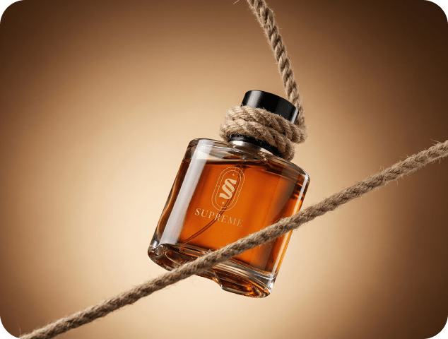 Supreme luxury perfume bottle with amber fragrance suspended by a rustic rope against a warm brown studio background